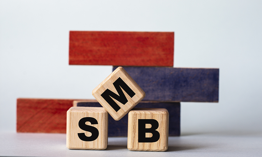 SMB (Smail-to-Medium Business) - word on wooden cubes on a background of colored block on a light background. Business concept