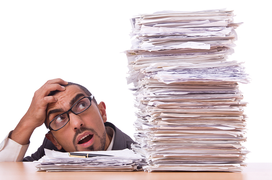 Busy businessman with lots of papers to show why ERP Accounting Software is better