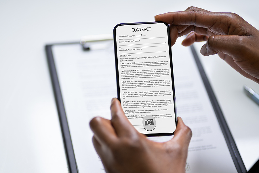 Person using an OCR to scan a contract agreement to demonstrate how Smart Capture OCR works