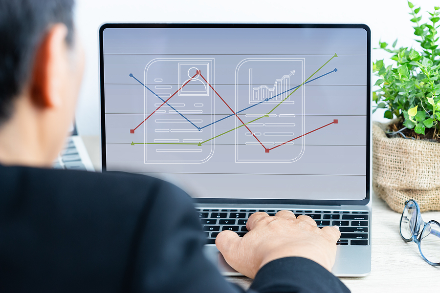Forecasting and Budget Reporting Businessman working analyzing business results in quarter with digital financial report graph layer on laptop computer, showing sales or statistics charts in workplace office. Annual reports ideas